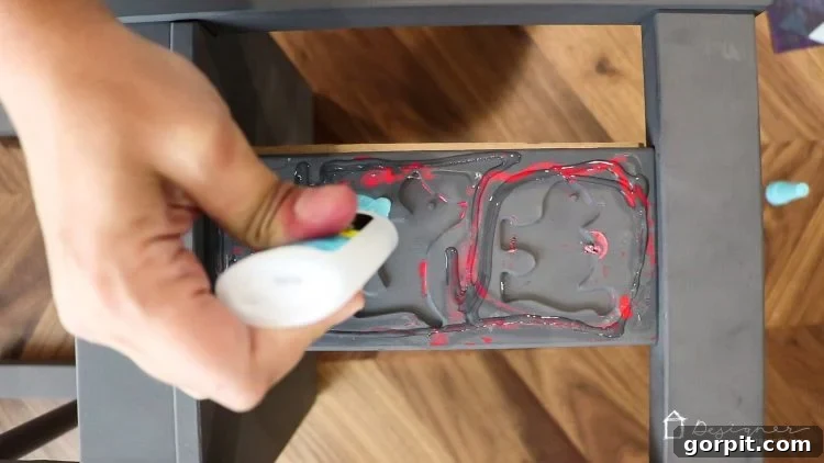 Gluing a fabric-covered chipboard panel to the front of an IKEA Kritter chair back with strong adhesive.