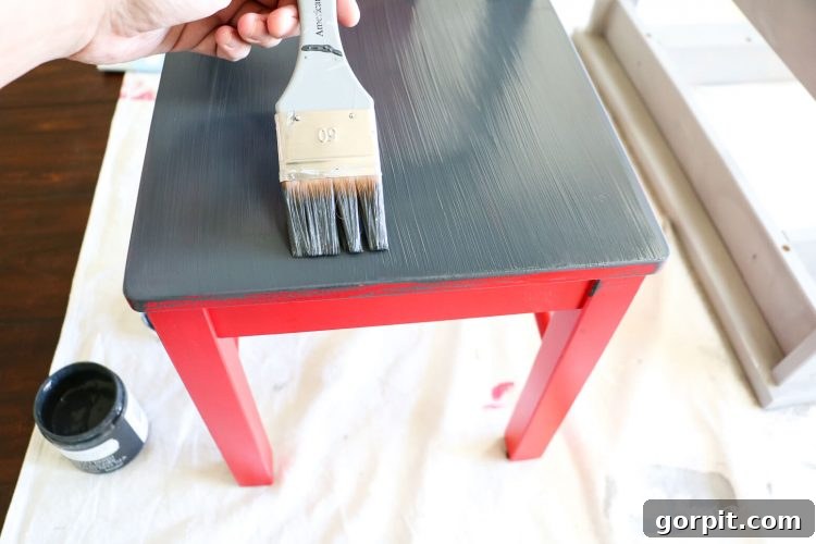 IKEA Kritter chairs painted in a cohesive dark gray chalk paint, ready for fabric panels.