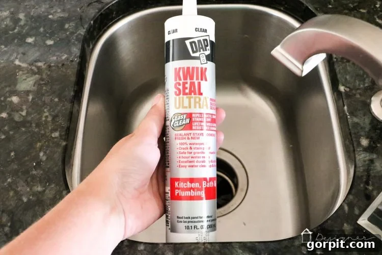 Seamless Caulk Replacement Guide 10 Applying a fresh bead of DAP Kwik Seal Ultra caulk to a clean kitchen sink joint.