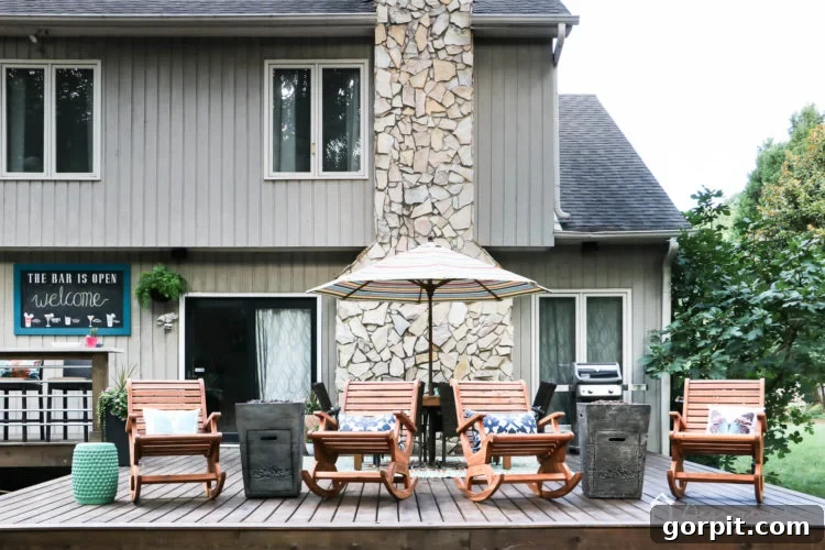 A stunning, newly renovated DIY deck featuring stylish outdoor furniture and modern decor, perfect for entertaining. The deck showcases a clean, neutral brown stain and ample seating areas.