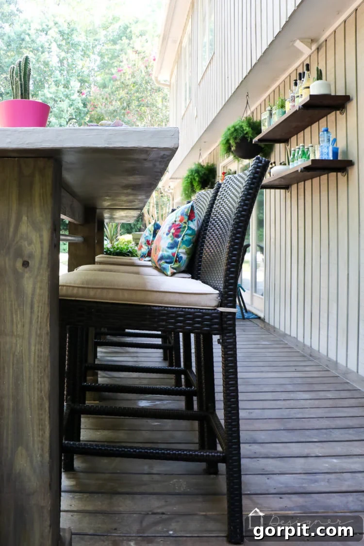 The custom-built DIY outdoor bar on the deck, equipped with comfortable bar stools and styled for entertaining, offering both functionality and additional seating.