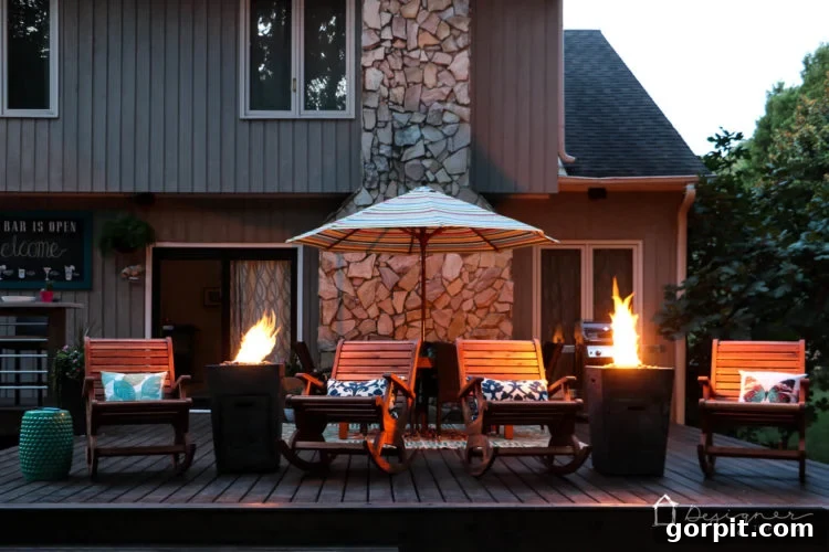 The renovated deck illuminated by the soft glow of the fire columns at dusk, showcasing the magical ambiance created for outdoor entertaining.