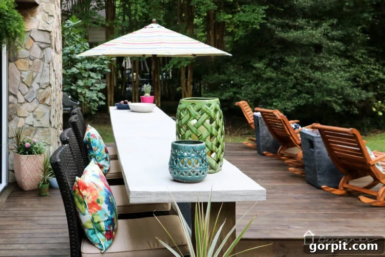 A panoramic view of the renovated deck, highlighting the new wrap-around stairs, the sophisticated outdoor dining area, and the harmonious blend of furniture styles.