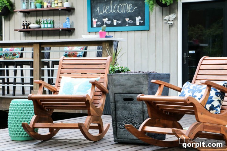 A cozy corner of the DIY deck, furnished with oversized Acacia rocking chairs and flanked by modern fire columns, creating an inviting and warm atmosphere.