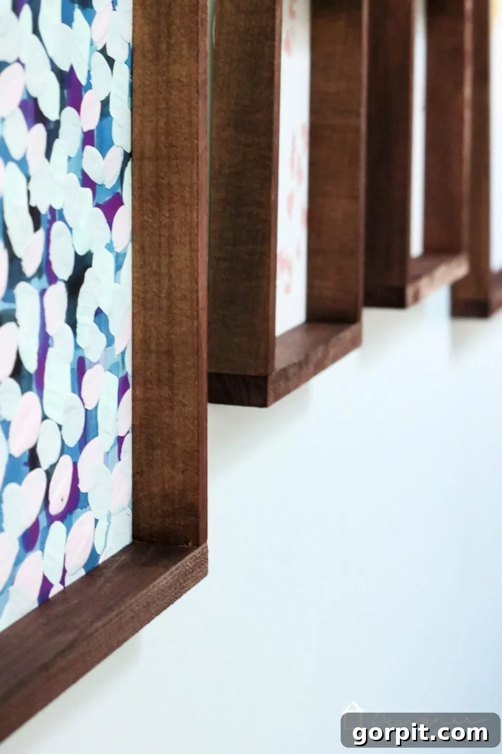 Crafting Stunning Frames for Your Big Art 14 A close-up view of wall art frames seen at an angle. The frames are dark wood stained.