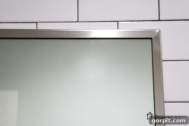 Before and after: The stainless steel frame of the commercial mirror before applying the Rub N Buff faux gold finish.