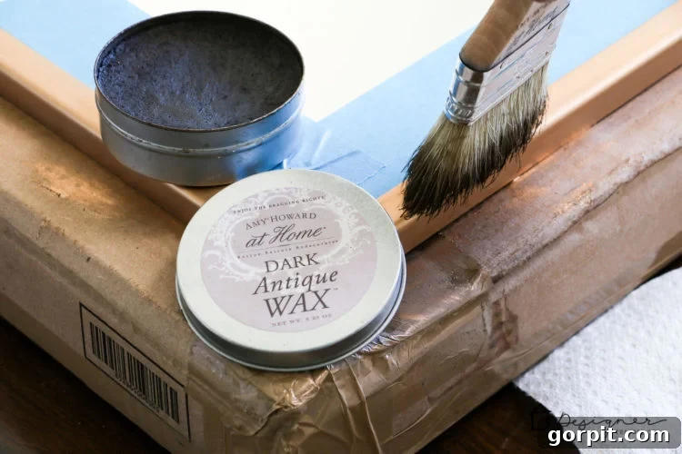 Applying Amy Howard At Home Dark Wax to create an authentic aged patina on the Rub N Buff faux gold finish.