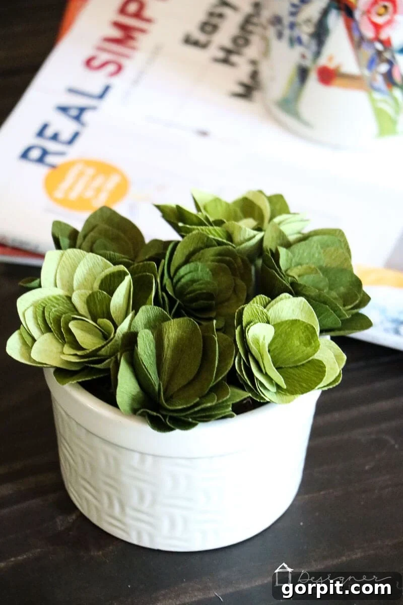 Cricut's Edge: Crafting Impeccable Crepe Paper Succulents 12 Styled home decor with DIY crepe paper succulents in a ceramic dish on a stack of books.