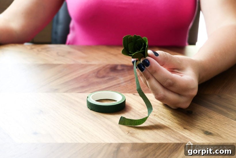 Cricut's Edge: Crafting Impeccable Crepe Paper Succulents 8 Securing the base of the rolled crepe paper succulent with green floral tape.