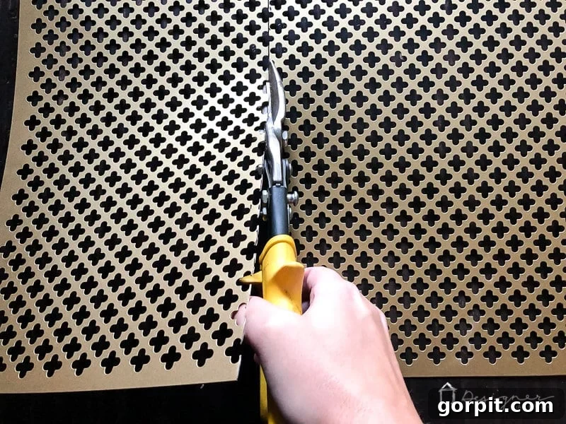 Using tin snips, carefully mark and cut your decorative aluminum sheet to the exact dimensions required for your door's kick plate. This step is easier than it looks!