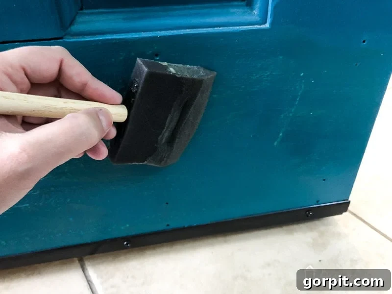 The door surface also needs a precise application of contact cement, mirroring the kick plate, to create an incredibly strong, seamless bond.