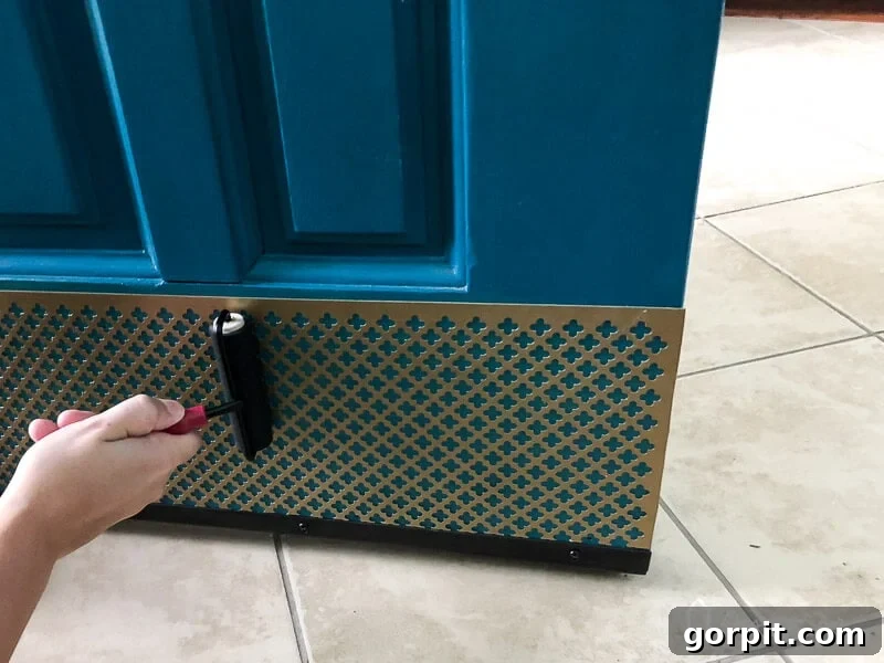 Firmly press your new screw-free kick plate into place using a rigid brayer, ensuring full contact and a lasting bond across the entire surface.