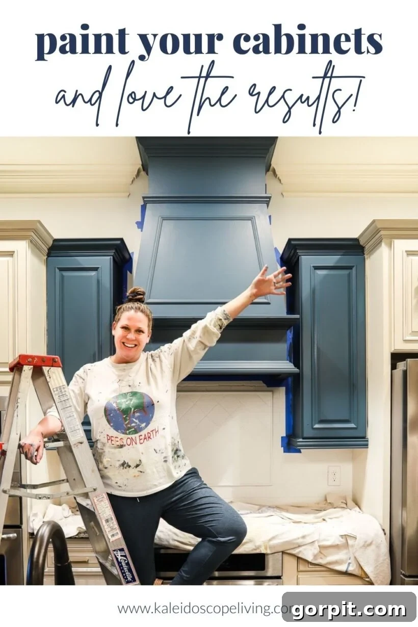 Tasha, of Kaleidoscope Living, stands on the lower rung of a ladder with her arm outstretched to show the best paint for kitchens. The text below reads, "www.kaleidoscopeliving.com."