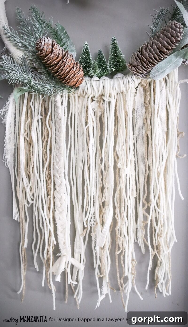 DIY Boho Winter Wreath displayed on a light-colored wall with warm lighting