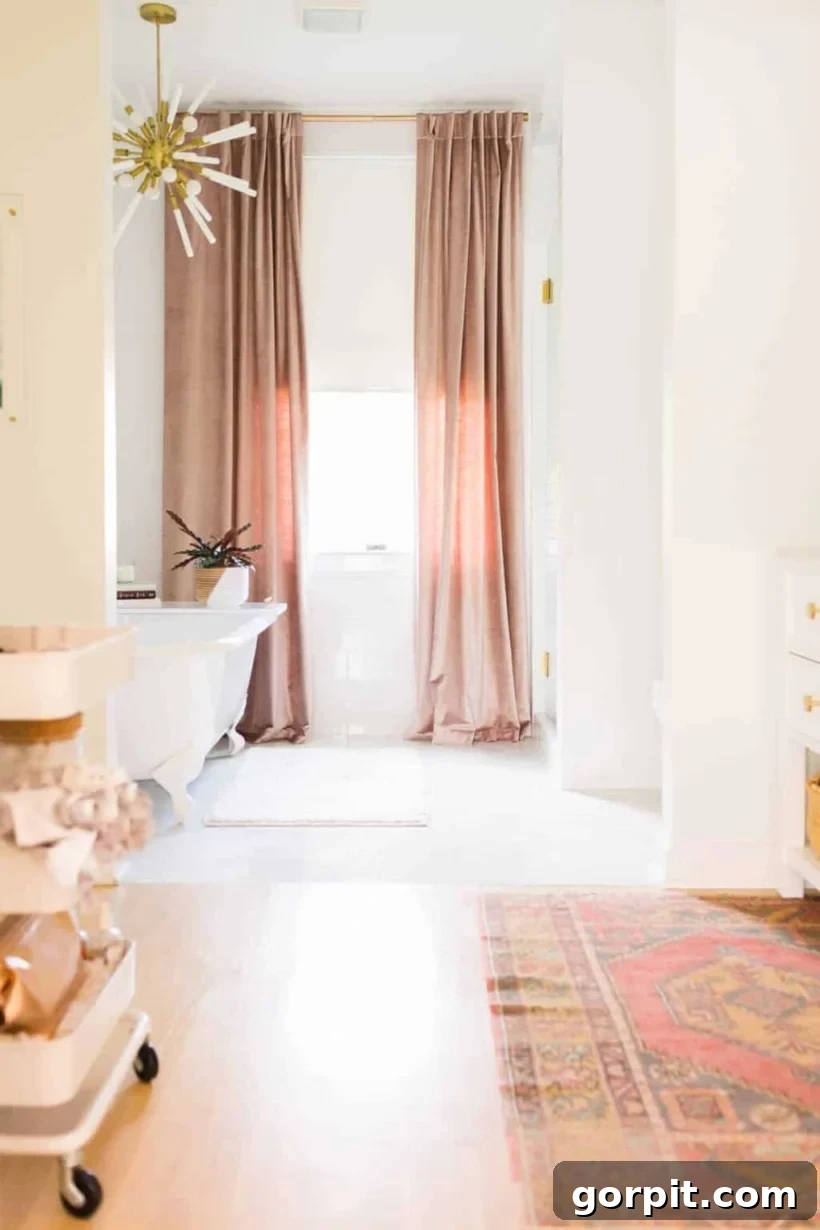 Make Small Rooms Feel Bigger 9 Genius Hacks 5 Floor to ceiling curtains frame a sunny window against the back wall of a long primary bathroom. Photo courtesy of "A Beautiful Mess."