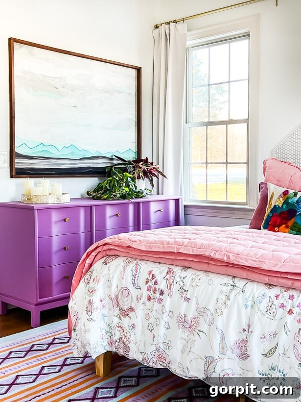 Make Small Rooms Feel Bigger 9 Genius Hacks 9 A purple dresser next to a pink bed and bright window. The furniture has legs to make a small room look bigger.