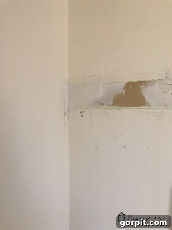 Wet spackling paste applied to a larger drywall hole, before drying and sanding.