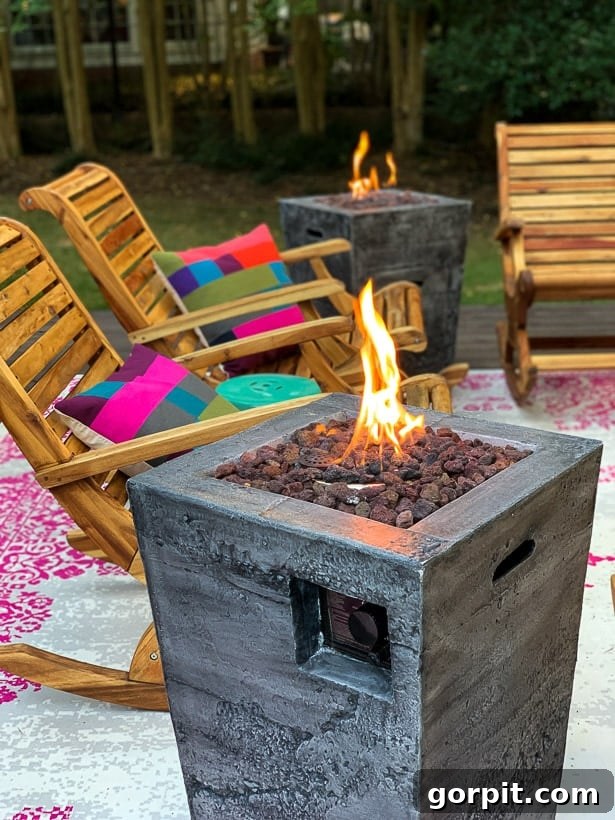 Fire columns on colorful backyard deck next to rockers and colorful checkered pillows, creating an inviting atmosphere.