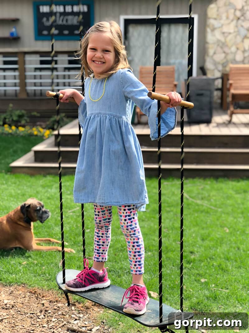 Another view of the DIY skateboard swing with a child happily swinging, showcasing its sturdy construction.