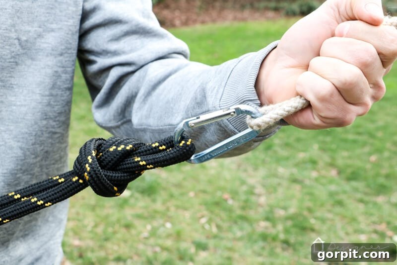 A demonstration of using a weighted carabiner and rope to thread the main swing rope over a high tree branch.