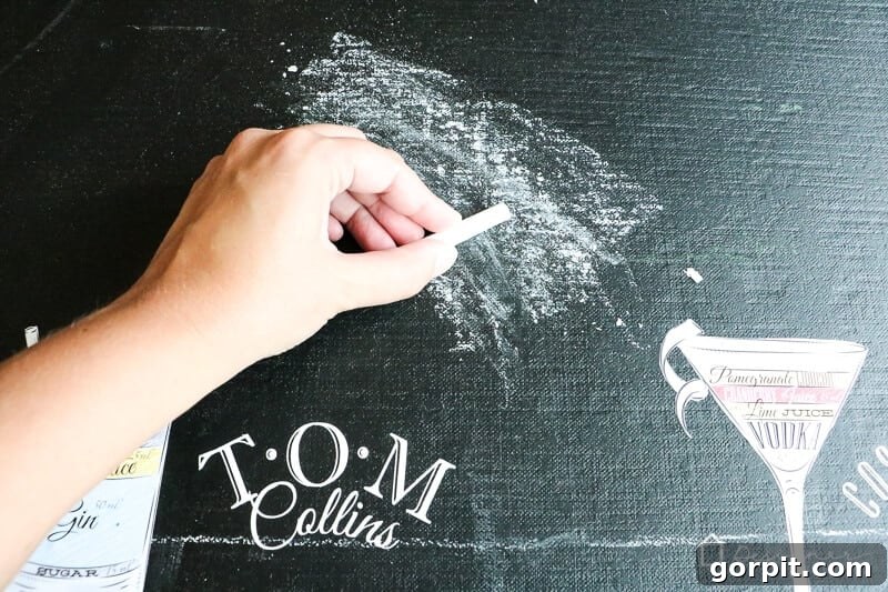 Build a Custom Outdoor Chalkboard 8 A hand rubbing chalk across the entire surface of the newly painted chalkboard