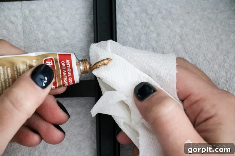 Applying Rub N' Buff in Antique Gold to a plastic frame