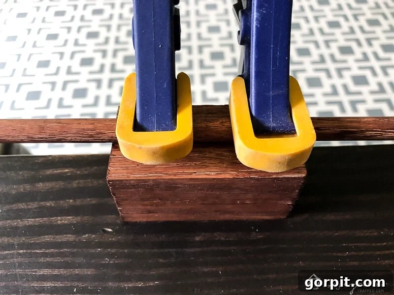 Tangle-Free Treasures: Easy DIY Jewelry Organization 11 Wood dowel and block secured together with clamps while the glue dries.