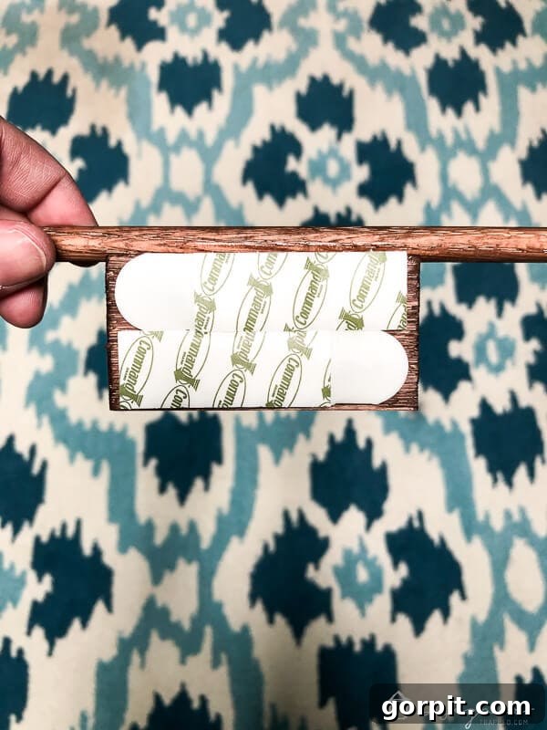 Tangle-Free Treasures: Easy DIY Jewelry Organization 12 Close-up of Command picture hanging strips applied to the back of a wood block.