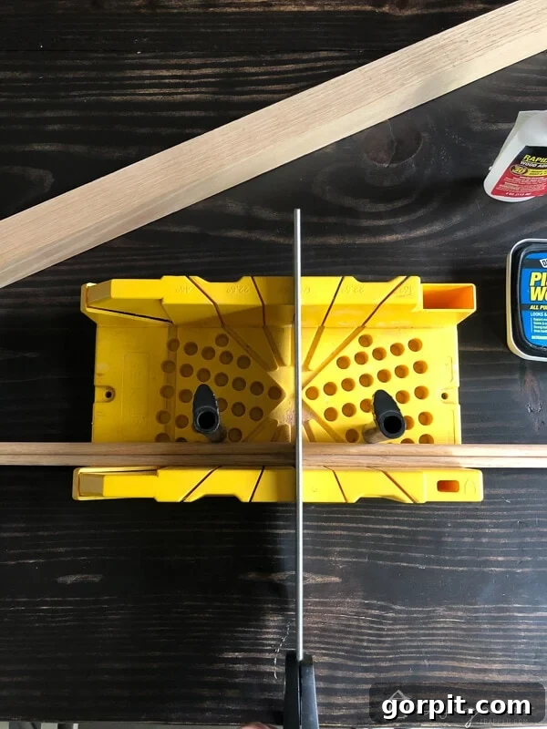 Tangle-Free Treasures: Easy DIY Jewelry Organization 9 Person using a hand saw to cut a wood dowel in half.