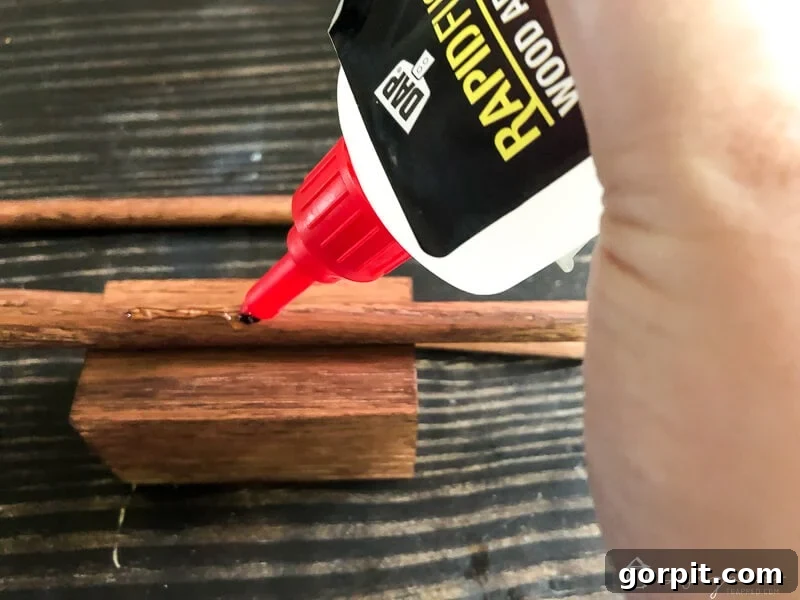 Tangle-Free Treasures: Easy DIY Jewelry Organization 10 Applying DAP Rapid Fuse to a wood dowel before attaching it to a block.