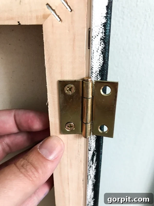 DIY abstract art installed on hinges to cover wall electronics