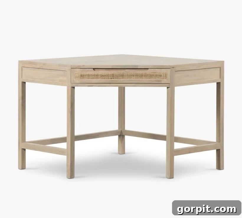 A small, bare wood corner cane desk with central drawer against a white background, highlighting its beautiful texture and elegant design.