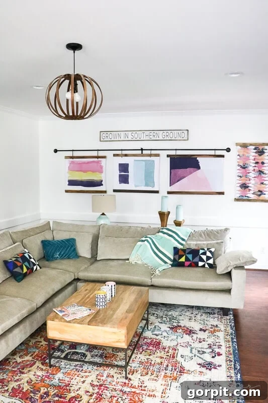 Artistic watercolor prints displayed in DIY half frames above the West Elm Harmony sectional in a colorful family room.