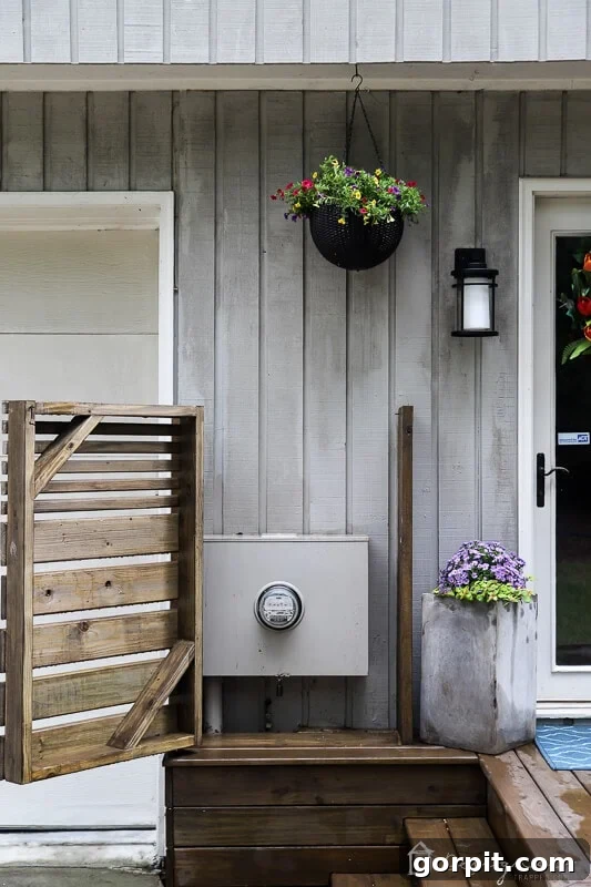 DIY Outdoor Electrical Box Enclosure 12 image of a wood DIY electrical box cover with a hinged door for easy access installed on the exterior of a home