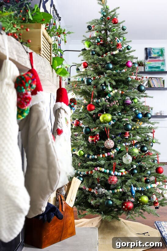 A Kaleidoscope Christmas 3 A beautifully decorated colorful Christmas tree standing tall in a bright living room, showcasing a mix of unique ornaments and garlands.
