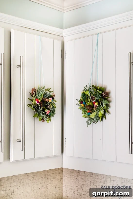 Mini wreaths can be such a cute and festive touch when decorating for Christmas. We added mini wreaths to our kitchen cabinets this year, and they are my new favorite thing! In this post, I share how we customized and hung our mini wreaths, plus I've rounded up the cutest mini wreaths out there that you can buy! #christmasdecor #miniwreaths #christmaswreaths #christmasdecorations #wreath #wreaths