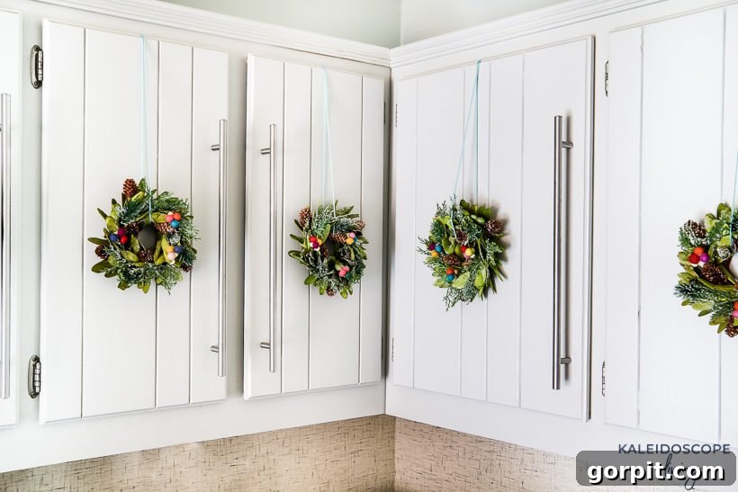Mini wreaths can be such a cute and festive touch when decorating for Christmas. We added mini wreaths to our kitchen cabinets this year, and they are my new favorite thing! In this post, I share how we customized and hung our mini wreaths, plus I've rounded up the cutest mini wreaths out there that you can buy! #christmasdecor #miniwreaths #christmaswreaths #christmasdecorations #wreath #wreaths