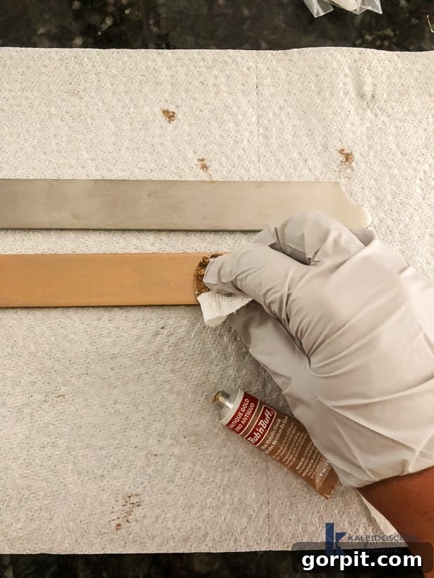 using Rub n Buff to change color of metal brackets, showing a hand applying the product to a metallic bracket for a custom finish