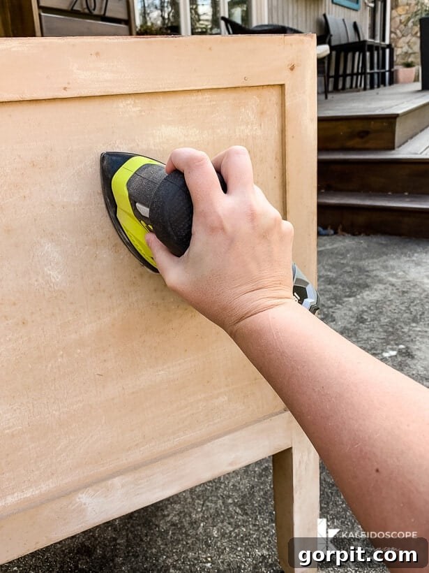 Chalk Paint Furniture Makeovers Step by Step 3 Sanding a piece of furniture to prepare for painting, highlighting the importance of proper surface preparation for a lasting finish.
