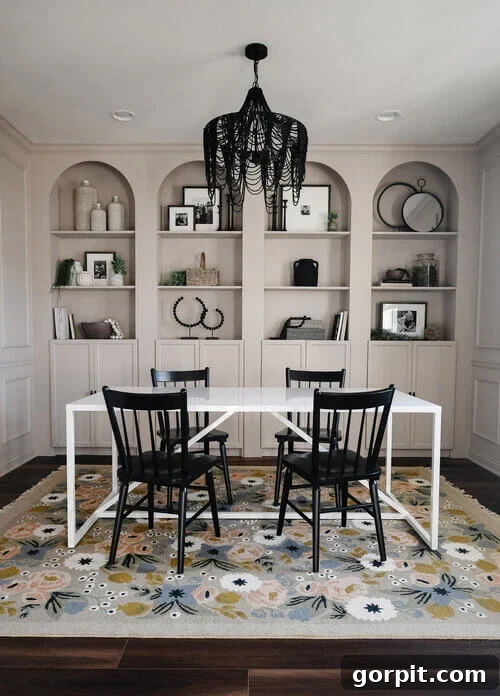Transform Your IKEA: Bookshelf & Cabinet Built-In Hacks 8 Stunning Billy bookcase built-ins with added arches are flush against the dining room wall, creating an elegant focal point. The room features a striking black chandelier, a pristine white dining table, and chic black chairs, completing a sophisticated and dramatic aesthetic.