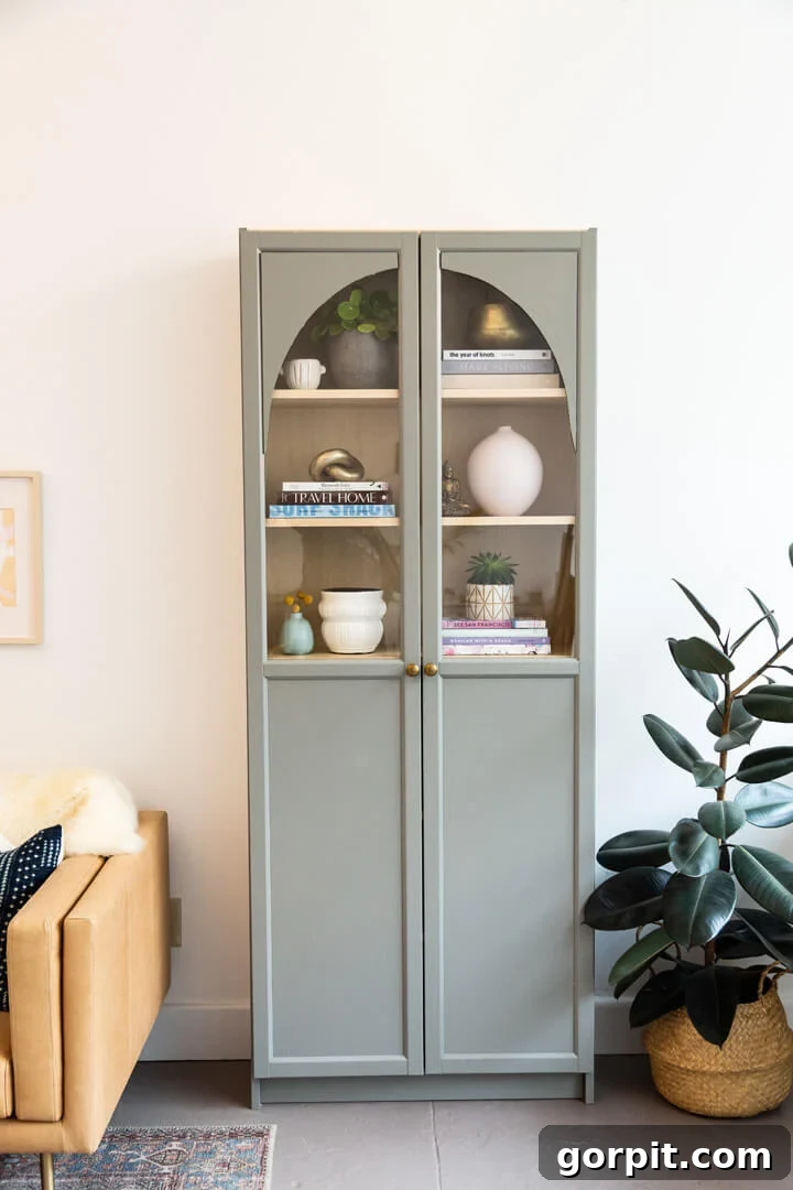 Transform Your IKEA: Bookshelf & Cabinet Built-In Hacks 7 An IKEA Billy bookcase ingeniously turned into a DIY arched cabinet, painted in a serene light sage green, showcasing a remarkable custom transformation.
