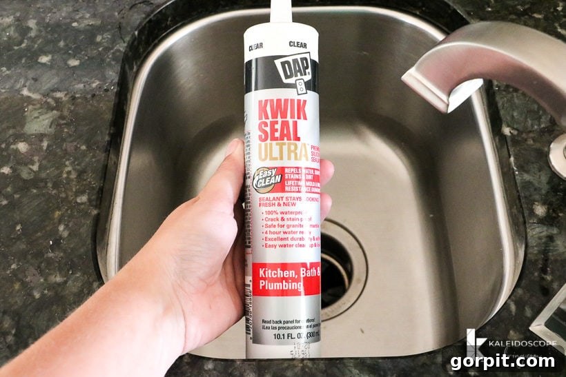 DAP Kwik Seal Ultra tube held above a small stainless-steel sink, ready for application.