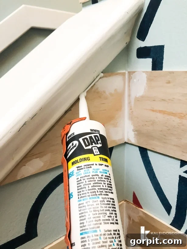 Close-up of a hand using a DAP caulk gun to caulk the edges of a plank wall, demonstrating proper application.