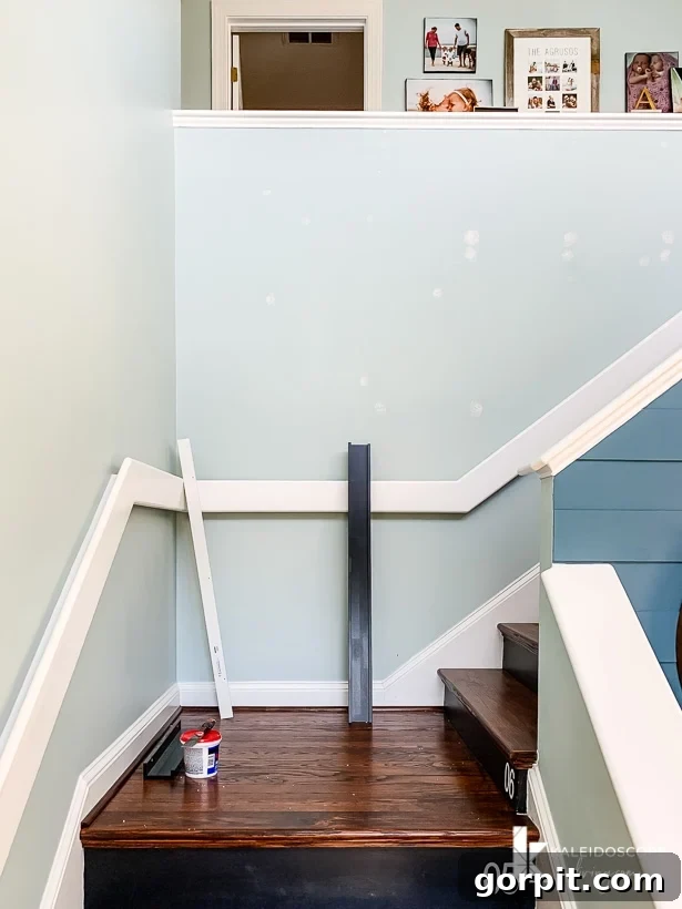 A freshly painted staircase wall demonstrating the seamless blend achieved by repainting from corner to corner when matching existing paint colors.