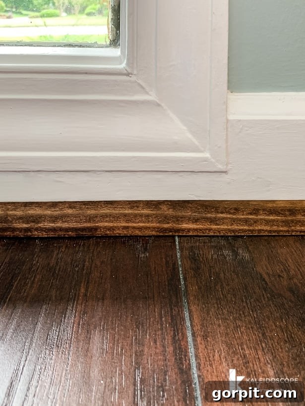 Easy Ways to Repair Chipped Baseboards 11 Freshly repaired and painted baseboard molding with new quarter round, looking crisp and clean after the DIY project