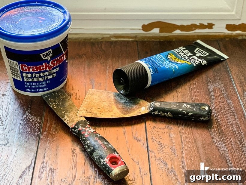 Easy Ways to Repair Chipped Baseboards 3 Essential tools and materials for baseboard repair, including spackle, putty knife, sandpaper, caulk, and paint ready for use