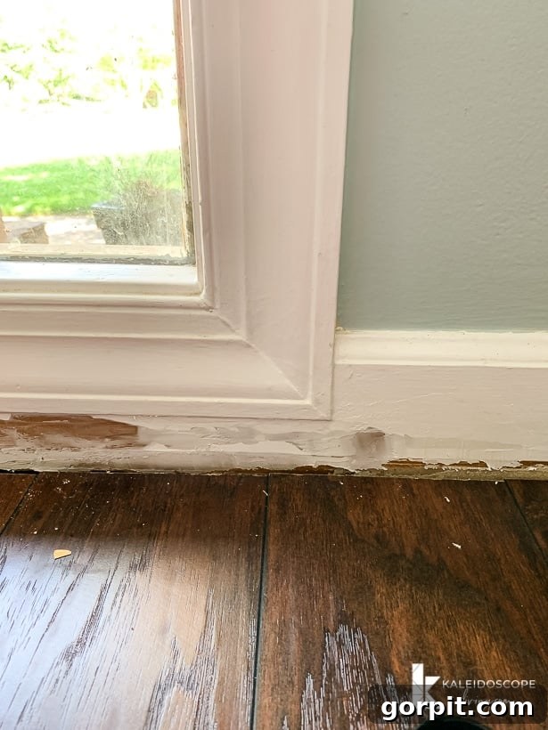 Easy Ways to Repair Chipped Baseboards 6 First coat of DAP Alex Plus Spackling applied to a damaged baseboard, showing initial patching