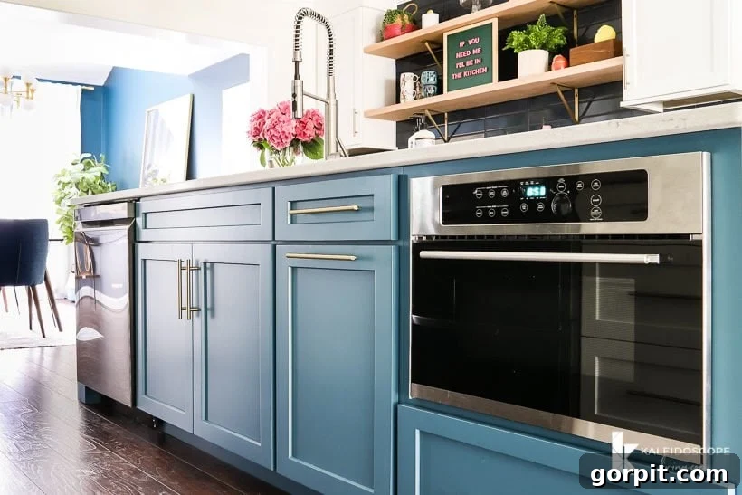 Vibrant Kitchen Transformation Unveiled 16 large teal kitchen island painted in Silken Peacock by Sherwin Williams, showcasing integrated sink