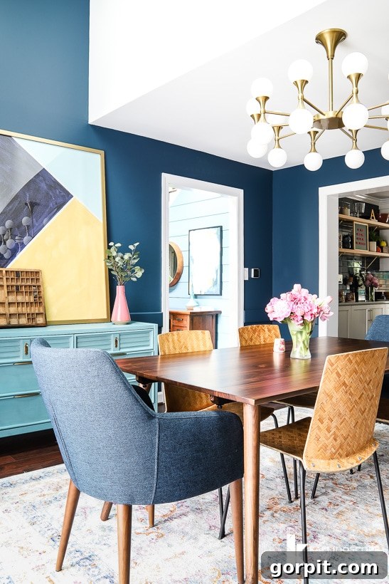Eclectic dining room featuring a mid-century modern table and restored vintage side chairs