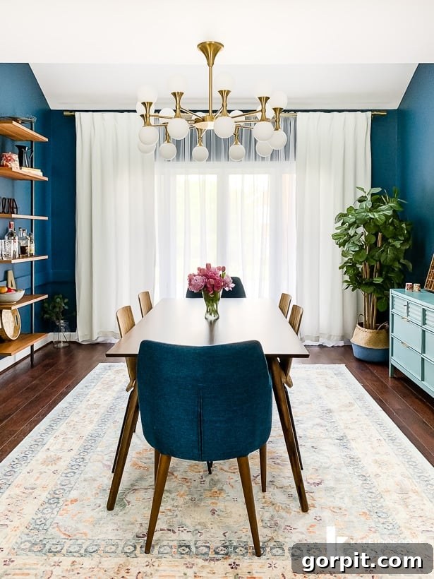 Eclectic navy blue dining room showcasing a blend of modern and vintage design elements